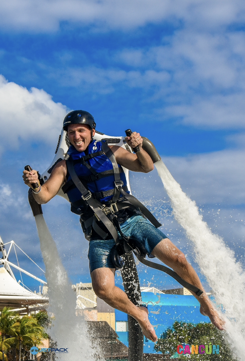 Kevin flying a jetpack over the water in Cancun