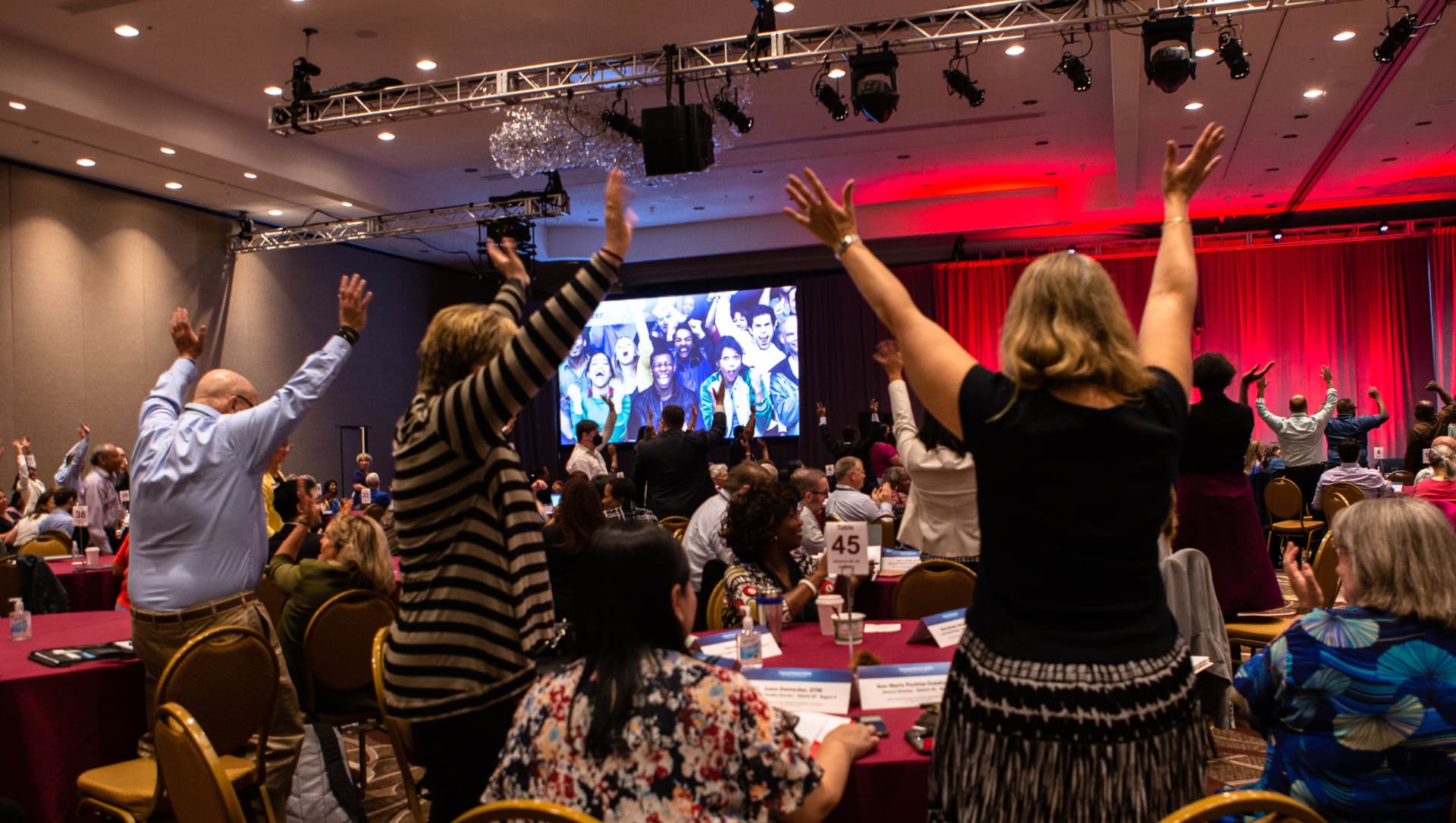 Conference audience with hands raised during Kevin's keynote
