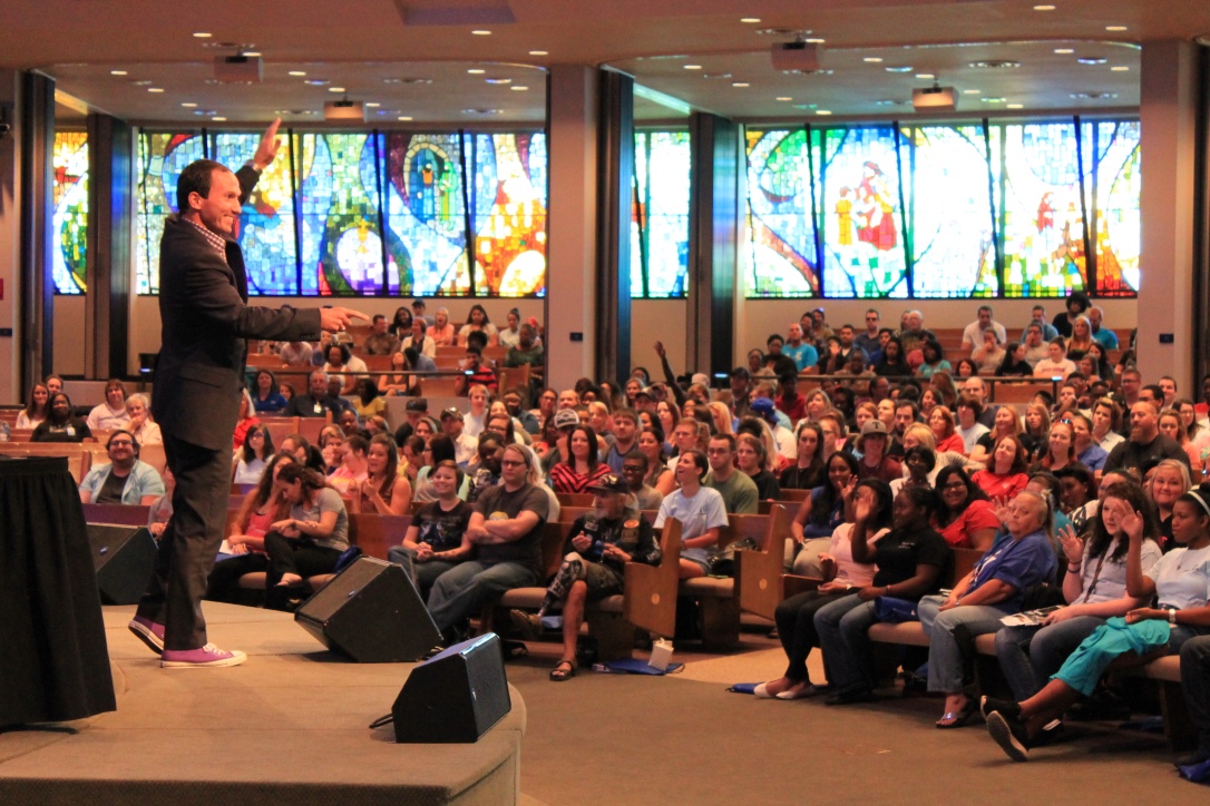 Kevin speaking to a packed school auditorium