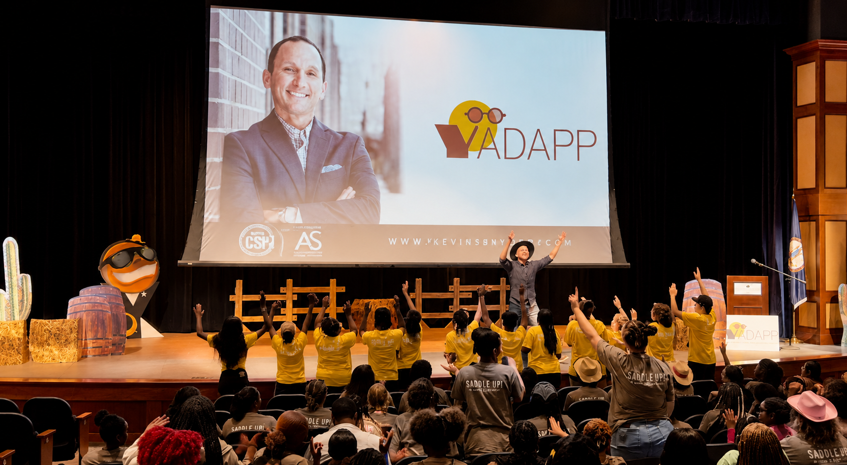 Kevin Snyder speaking to a youth audience with hands raised